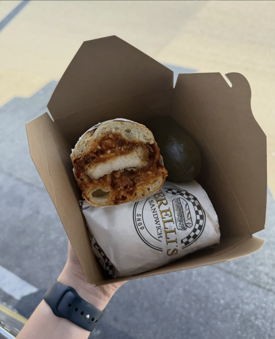 Zerelli’s Chicken Parmigiana sandwich with crispy chicken, cheese, and marinara in a takeaway box