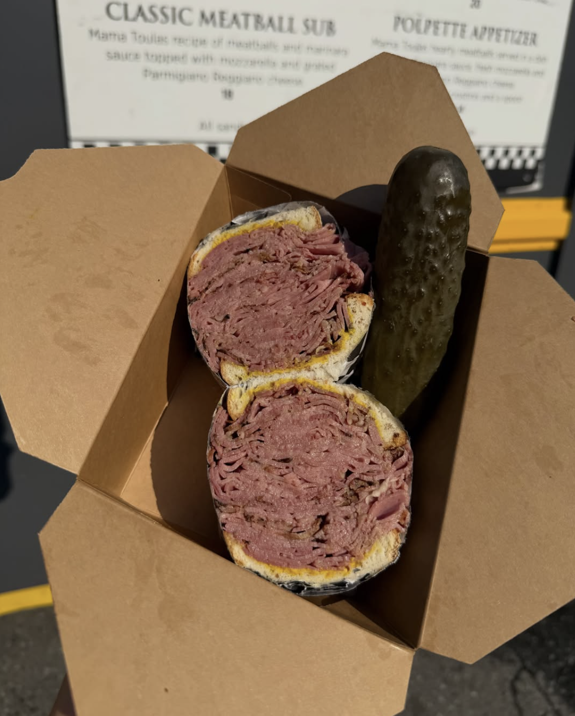 Montreal Smoked Meat piled high between slices of rye, served with a pickle